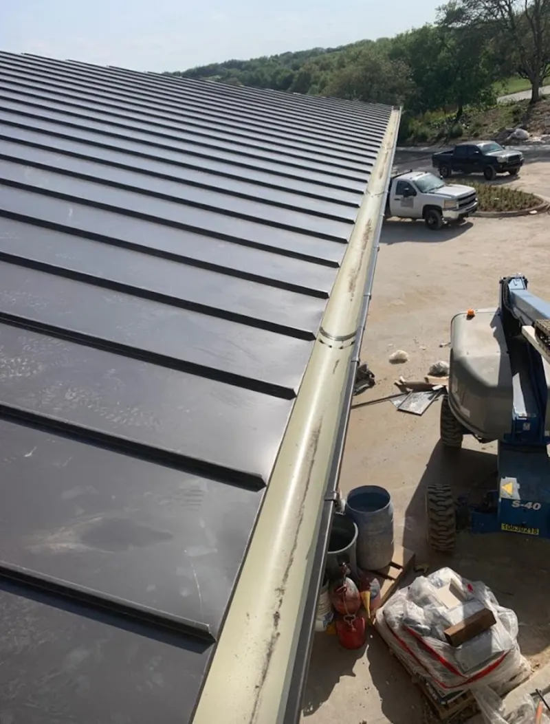Standing seam panel and gutter detail on a metal roofing jobsite in Rochester